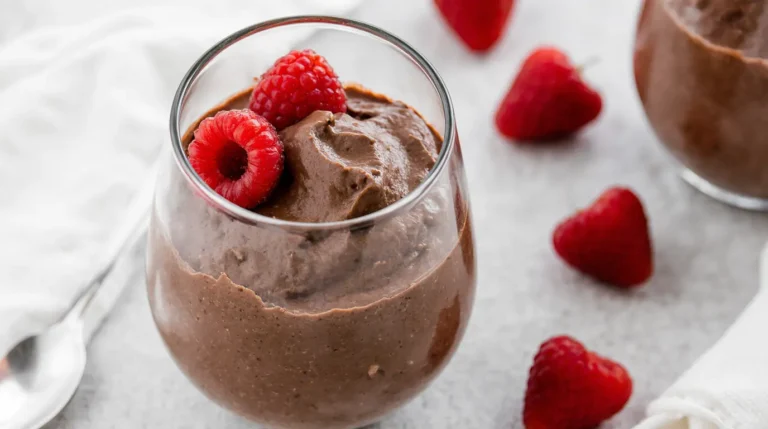 Creamy homemade protein chocolate mousse in a glass with raspberries