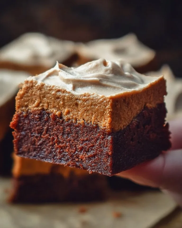 Delicious brownies with silky frosting on a white plate